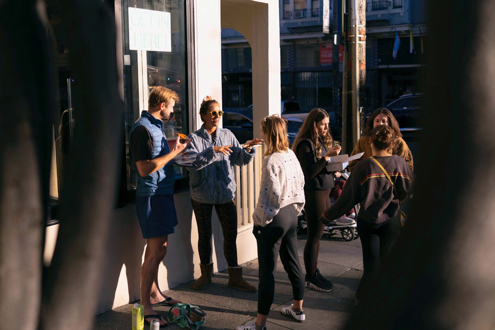 Yoga teacher training students chatting in the sun outside the studio entrance
